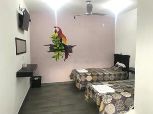 a room with two beds and a parrot on the wall at HOTEL LOS PINOS CENTRO in Tuxtla Gutiérrez