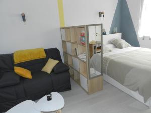 - une chambre avec un lit, un canapé et un miroir dans l'établissement L IMPREVU, à Chartres