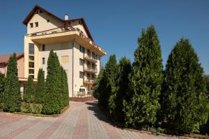 ein großes Gebäude mit Bäumen davor in der Unterkunft Grand Hotel in Braşov