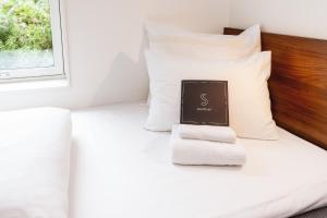 a book sitting on a bed with a pile of towels at Smarthotel Tromsø in Tromsø