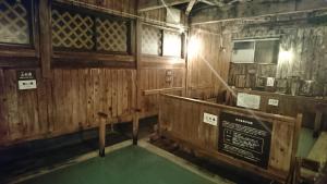 an inside view of a wooden cabin with a green floor at Yachi Onsen in Towada