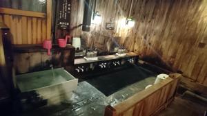 a bath room with a tub and a sink at Yachi Onsen in Towada