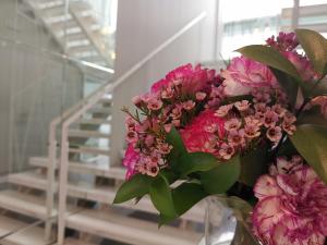 un ramo de flores rosas en un jarrón de cristal en Hotel Boutique Caireles, en Córdoba