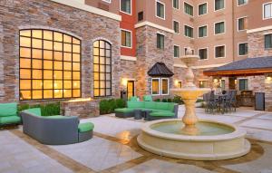 a courtyard with a fountain and chairs and a building at Holiday Inn Express & Suites - Gainesville I-75, an IHG Hotel in Gainesville