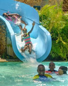 a group of children playing on a water slide at Sarova Whitesands Beach Resort & Spa in Mombasa