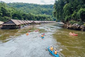 a group of people in kayaks on a river at River Kwai Jungle Rafts in Sai Yok