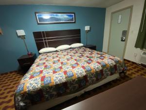 een slaapkamer met een groot bed en een kleurrijke quilt bij Lodge Inn Wrightstown - Fort Dix in Wrightstown