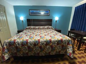 een slaapkamer met een bed met een kleurrijke quilt bij Lodge Inn Wrightstown - Fort Dix in Wrightstown