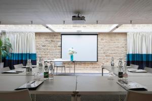 a conference room with tables and chairs and a large window at Le 123 Sébastopol - Astotel in Paris