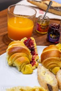 a plate of pastries on a table with a glass of orange juice at Dare Lisbon House in Lisbon