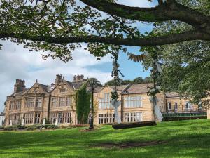 an image of a large building with a green lawn at Hollins Hall Hotel, Golf & Country Club in Bradford