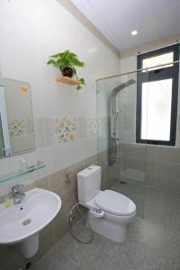 La salle de bains est pourvue de toilettes, d'un lavabo et d'une douche. dans l'établissement Luan'S Villa, à Đà Lạt