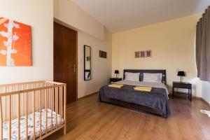 1 dormitorio con 1 cama y 1 cuna en Alexander Apartments Airport, en Spáta