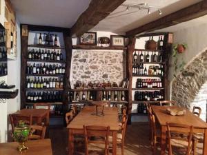 a restaurant with wooden tables and bottles of wine at Residenza d'Epoca Borgodifiume in Fiumefreddo Bruzio