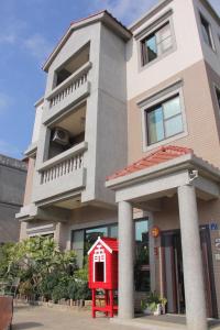 a house with a red dog house in front of it at 八八小屋心享民宿 in Jinning