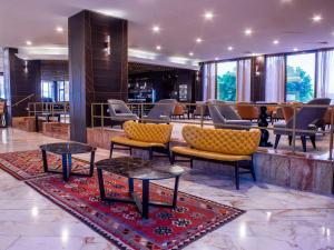 un hall avec des chaises et des tables dans un bâtiment dans l'établissement Caesar Premier Tiberias Hotel, à Tibériade