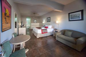 une chambre d'hôtel avec un lit, un canapé et une table dans l'établissement Ramada by Wyndham & Suites South Padre Island, à South Padre Island