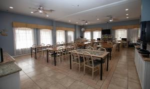 - une salle à manger avec des tables, des chaises et des fenêtres dans l'établissement Ramada by Wyndham & Suites South Padre Island, à South Padre Island