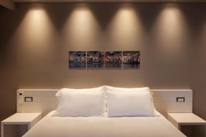 a bedroom with a bed and two paintings on the wall at Il Casato Deluxe Rooms in Scilla