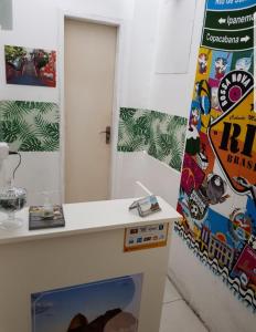 una habitación con un mostrador y una pared con carteles en Sobrado Botafogo Guesthouse, en Río de Janeiro