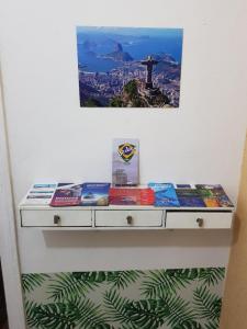 un estante con libros con una foto en la pared en Sobrado Botafogo Guesthouse, en Río de Janeiro