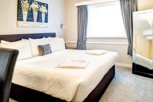 Best Western Weymouth Hotel Rembrandt في ويماوث: غرفة نوم بسرير كبير ونافذة