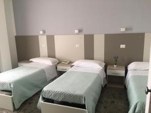 a room with three beds in a room at Piccolo Hotel Lamezia in SantʼEufemia Lamezia