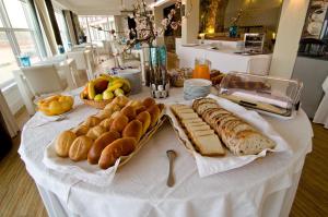 ein Tisch mit Brot und anderen Lebensmitteln darauf in der Unterkunft Estalagem Muchaxo Hotel in Cascais