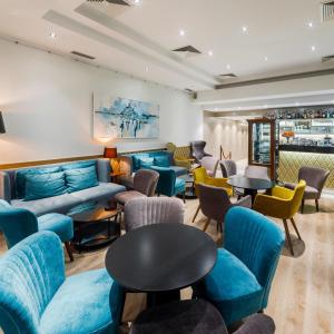 a waiting room with blue couches and tables at Pansion Waldinger in Osijek