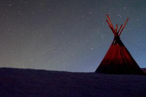 une tente rouge sous un ciel étoilé dans l'établissement Lofoten Camp, à Stamsund