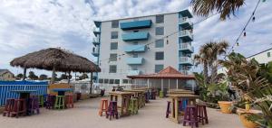 a group of tables and chairs in front of a building at Fountain Beach Resort - Daytona Beach in Daytona Beach