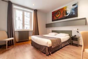 a hotel room with a bed and a window at Hotel Esplanade in Strasbourg