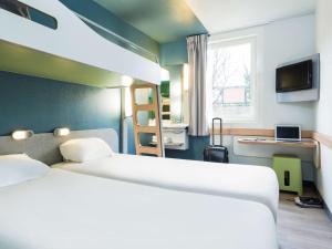 ibis budget Paris Porte De Montmartre tesisinde bir odada yatak veya yataklar