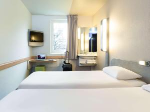 ibis budget Paris Porte De Montmartre tesisinde bir odada yatak veya yataklar