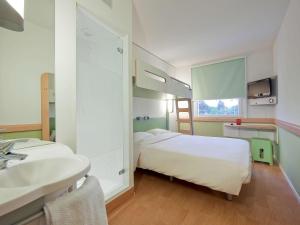 Una cama o camas en una habitación de ibis budget Genève Petit-Lancy