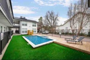 a backyard with a swimming pool and green grass at The Alcove Dallas Near Downtown Fun Nightlife in Dallas