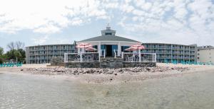 ein Hotel am Strand mit Liegestühlen und Sonnenschirmen in der Unterkunft Breakers Resort - Lakeside in Saint Ignace