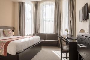 une chambre d'hôtel avec un lit et un canapé dans l'établissement Mannin Hotel, à Douglas