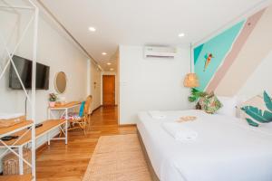 a bedroom with a bed and a desk and a table at Summer Stay Sattahip in Sattahip