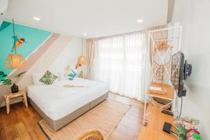 a bedroom with a white bed and a window at Summer Stay Sattahip in Sattahip