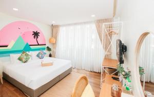 a bedroom with a bed with a surfboard on the wall at Summer Stay Sattahip in Sattahip