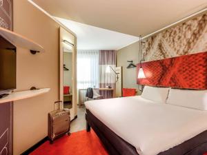 Un pat sau paturi într-o cameră la ibis Hotel München City