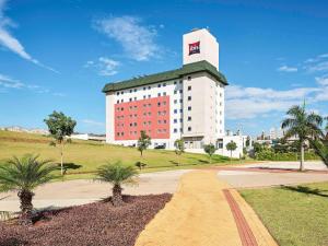 un grande edificio bianco con tetto verde di ibis Londrina Shopping a Londrina