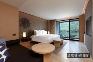 une chambre d'hôtel avec un lit et une table dans l'établissement MU Jiaoxi Hotel, à Jiaoxi