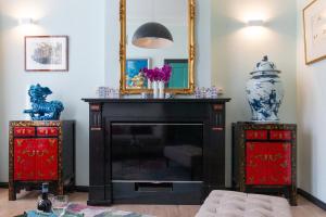 a living room with a fireplace and a mirror at B&B Blossom in Amsterdam