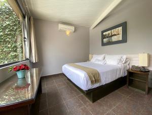 a bedroom with a white bed and a glass table at Hotel Villa Condesa in Mexico City