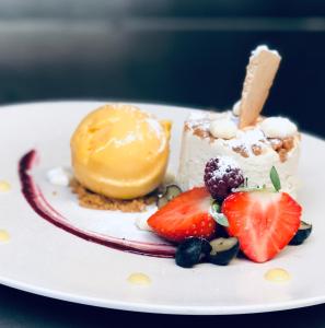 een dessert met fruit op een witte schaal bij A Park View Hotel in Wolverhampton