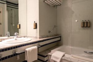 a bathroom with a tub and a sink and a bath tub at Parador de El Hierro in Las Casas