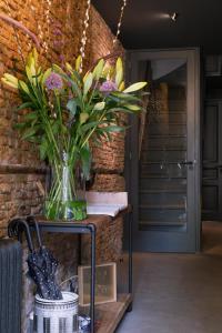 a vase of flowers on a table next to a brick wall at Villa360 in Amsterdam