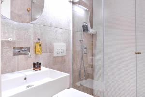 a bathroom with a sink and a shower with a mirror at My Story Hotel Tejo in Lisbon